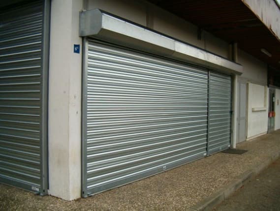 Rideaux métalliques à lames pleines galvanisées fermant deux locaux commerciaux